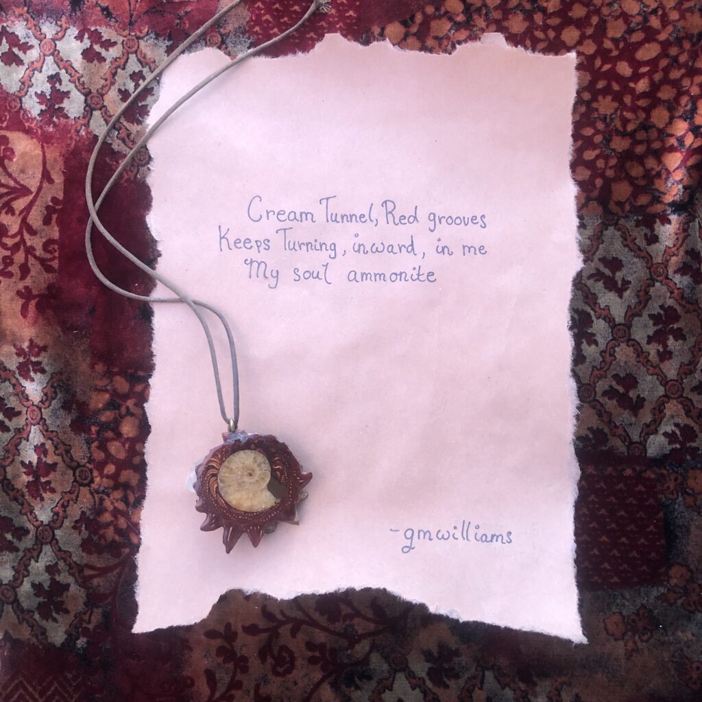 Haiku Poem on a brown piece of paper with an ammonite pendant